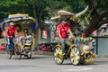 Tourist entertainment - trishaw on his customized tricycle transport, brightly decorated with children`s cartoon and flowers.