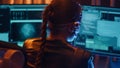 Cyberpunk girl backview types on keyboard multiple monitors with strings of code Royalty Free Stock Photo