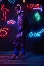 Cyberpunk shooting of model wearing contemporary sportswear against wall of neon