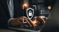 Cybersecurity concept person working on laptop with authentication and data protection shield for online security Royalty Free Stock Photo
