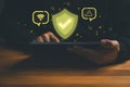 Cybersecurity and data protection concept showing a person using a tablet with shield icon Royalty Free Stock Photo
