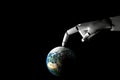 Cyborg hand playing with earth