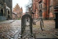 Cycle in the rain locked on the public bicycle stand in the churchyard of St. Mary`s Church, Lubeck, Germany, copy space, selecte Royalty Free Stock Photo