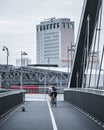 Cycler looking back captured riding across a bridge road with an electronic scooter standing by Royalty Free Stock Photo