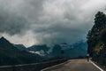 Cycler on a mountain road under stormy cloud Royalty Free Stock Photo