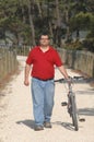 Cycler on the seaside walking with bike