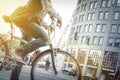 Cycling in the city. Man on bike in traffic with sun-flare. Royalty Free Stock Photo