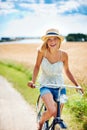 Cycling her way to wellbeing. Happy young woman riding a bicycle in the countryside. Royalty Free Stock Photo