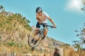 Cycling, jumping and man on bicycle in the countryside for fitness, stunt and freedom on blue sky background. Nature Royalty Free Stock Photo