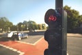 cycling lane traffic light shows red stop signal at large inner city junction with red marking strips and moving cars Royalty Free Stock Photo