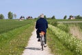 Cycling older man on Dutch countryside with Seawall