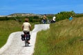 Cycling senior woman in summer clothing on the island of Terschelling