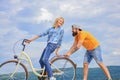 Cycling service. Mechanic helps maintain bicycle. Supportive service. Woman rides bicycle sky background. Man helps keep Royalty Free Stock Photo