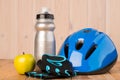 cycling - set of objects for playing sports on a wooden background - helmet, gloves, water bottle and apple Royalty Free Stock Photo