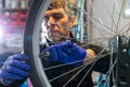 Cycle mechanist working on spokes on wheel in workshop