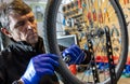 Cycle mechanist working on spokes on wheel in workshop