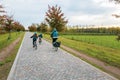 Cycling trip with the family in the autumn park. Mom and two children on bicycles. Autumn landscape Royalty Free Stock Photo
