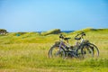 Cycling and wildcamping - two bicycles in the green machair field, with a tent in the background Royalty Free Stock Photo