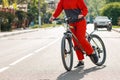 Cycling. A woman in red sportswear stands with a Bicycle on the road. Legs close-up. The rules of the road and environmentally