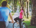 Cycling young couple. In the park. Beautiful bicycle lane.