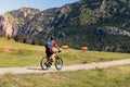 Cyclist with backpack in a meadow with cows