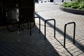 Five wheel stands of black metal bent tube in the shape of a rectangle in front of the retaining wall paving of granite cubes in Royalty Free Stock Photo