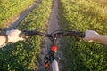 Cyclist on bike on field road. First person view