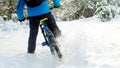 Cyclist in Blue Drifting on Mountain Bike in Beautiful Winter Forest. Extreme Sport and Enduro Biking Concept.