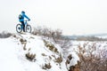 Cyclist in Blue Resting with Mountain Bike on Rocky Winter Hill. Extreme Sport and Enduro Biking Concept.