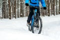 Cyclist in Blue Riding the Mountain Bike in Beautiful Winter Forest. Extreme Sport and Enduro Biking Concept. Royalty Free Stock Photo