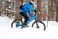 Cyclist in Blue Riding the Mountain Bike in Beautiful Winter Forest. Extreme Sport and Enduro Biking Concept. Royalty Free Stock Photo