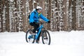 Cyclist in Blue Riding the Mountain Bike in Beautiful Winter Forest. Extreme Sport and Enduro Biking Concept. Royalty Free Stock Photo