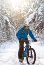 Cyclist in Blue Riding the Mountain Bike in Beautiful Sunny Winter Forest. Extreme Sport and Enduro Biking Concept. Royalty Free Stock Photo