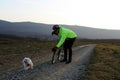 Cyclist calling his small dog to come closer