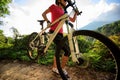 Cyclist carrying mountain bike climbing on summer forest trail Royalty Free Stock Photo