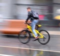 Cyclist on the city roadway in motion blur in rainy day Royalty Free Stock Photo