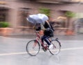 Cyclist on the city roadway in motion blur in rainy day Royalty Free Stock Photo