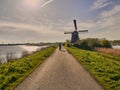 Cyclist on a country road near a windmill Royalty Free Stock Photo