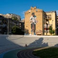 Cyclist on a cycle track rides against the background of a mural with a cyclist