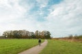 A cyclist drives through fields and forest country site. Beautiful autumn landscape with a cyclist