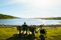 Cyclist enjoy panoramic view on break time by atlantic coast beach on bicycle touring around Ireland.