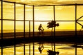 Cyclist exercising on the edge of beach against sunset.