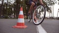 Cyclist go round traffic cones. Young handsome man riding a vintage bicycle. Sporty guy cycling at the park. Healthy Royalty Free Stock Photo