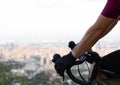 Cyclist grasping the handlebars of a road bike observing the city of Barcelona