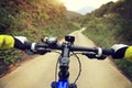 Cyclist hands riding mountain bike on forest trail