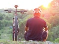 Cyclist with his mountain bike looking at the beautiful sunrise.
