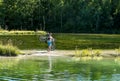 Cyclist holding his bicycle, standing in a river Royalty Free Stock Photo