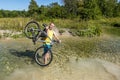 Cyclist holding his bicycle, standing in a river Royalty Free Stock Photo