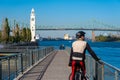 Cyclist looking at the Saint-Lawrence River, with Clock Tower and Jacques Cartier Bridge in background