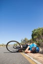 Cyclist lying on the road after an accident Royalty Free Stock Photo